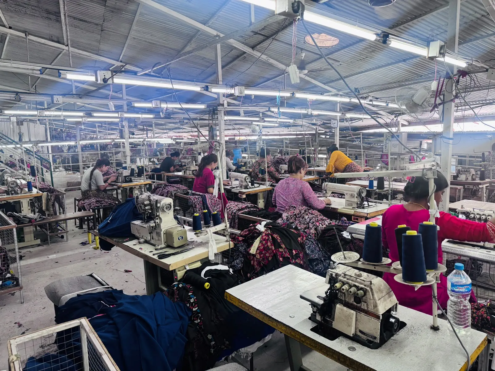 Sewing floor with operators working on patterned uniform garments