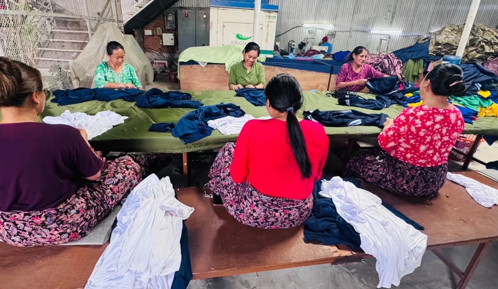 Thread trimming department staff carefully trimming loose threads from finished uniforms